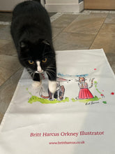 Load image into Gallery viewer, Britt’s black and white cat, strolling over Dog v cat tea-towel.

