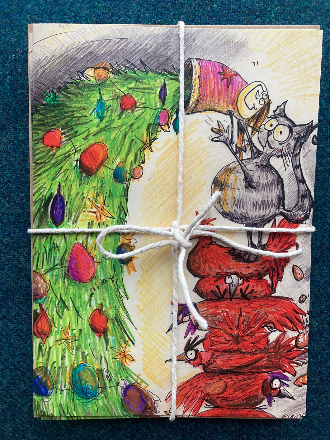 A5 sized Christmas cards featuring beautiful artwork by Britt. Blank inside for your own festive message or newsletter.   With brown craft envelopes. 5 in a pack.  Does not require large letter stamp. Hens and cat attempting to put angel on tree.